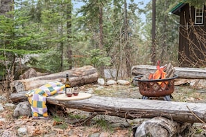 Outdoor fire pit surrounded by towering pines *not available during county burn ban
