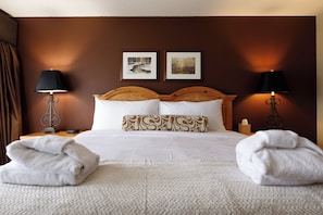 A warm and inviting bedroom with a plush king-size bed, soft lighting, and rustic wooden furniture for a cozy stay.