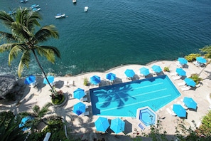 Take a refreshing swim in the shared pool surrounded by swaying palms and blue umbrellas.