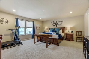 Spacious primary bedroom with a comfortable king-size bed, cozy seating area, and plenty of natural light. Includes an in-room treadmill for staying active and a peaceful atmosphere for unwinding..