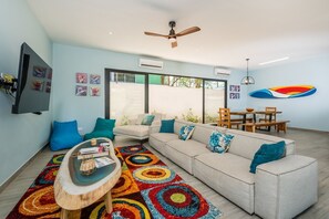 Vivid dining and living area with open kitchen.