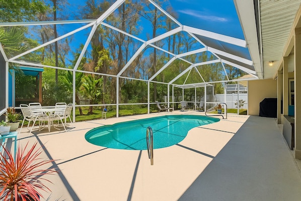 Enjoy your own private screened-in pool, surrounded by lush greenery and Florida sunshine—perfect for a refreshing dip without the bugs or debris