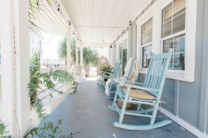 Large front porch with rocking chairs and swing, along with a built in bench providing plenty of seating 