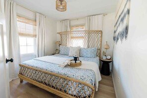 king bed with stunning rattan bedframe. wall hanging by local artist