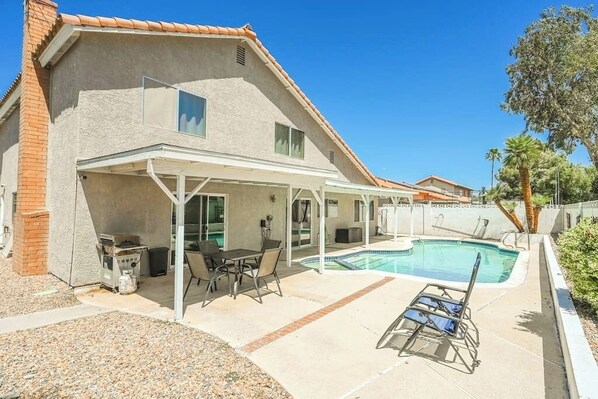 Sunny backyard with a private pool and comfortable seating.







