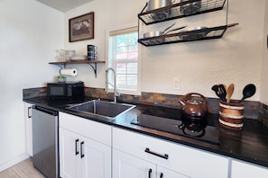 Lovely kitchen with farm sink, glass cook top and mini fridge.