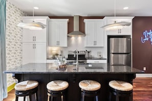 Open floor plan from the kitchen to living room, equipped with comfortable furnishings, plenty of natural light and all the kitchen essentials you would need. Seating at our dining table and the kitchen island.