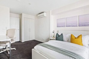 The master bedroom on level 1 with a double sized bed & plush pillows.
