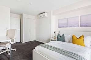 The master bedroom on level 1 with a double sized bed & plush pillows.