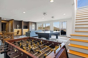 Challenge your friends and family in the ultimate entertainment space, featuring a foosball table, ping pong table, and a wet bar—perfect for game nights and fun-filled memories! 