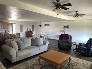 Open concept with two full size couches, large dining room table and recliners