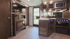 Main entrance opens to a stylish living/kitchen area with a warm, inviting feel.