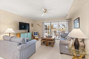 Spacious open-concept living area with comfortable couches (one is a sleeper sofa) and Smart TV