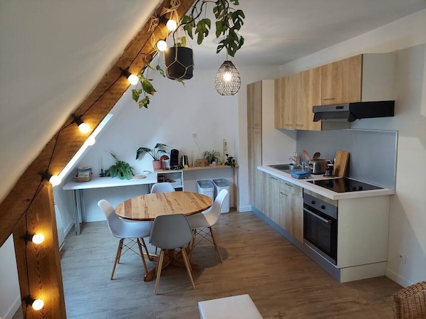 Vue d'ensemble de la cuisine et du coin repas depuis le coin salon.