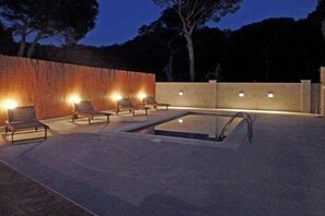 This inviting pool, glowing under the night sky, promises relaxation and rejuvenation.  Surrounded by the subtle light and gentle rustling of leaves, the spacious patio creates an intimate escape perfect for enjoying quiet evenings.
