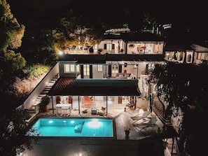 The villa in the evening, beautifully lit, atmospheric, and inviting to spend warm summer evenings on the terrace.