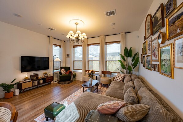 Cozy living room with large windows and vintage charm.
