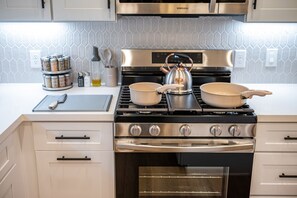Fully stocked kitchen with modern gas range.