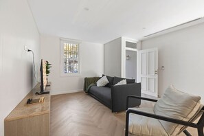 A cozy and stylish living room with warm tones, a sleek entertainment setup, and a chessboard for thoughtful moments. By Superhostly