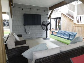 Sitting area under the home with tv and bench swing