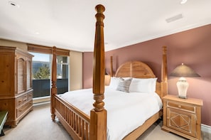Primary bedroom with a four poster king bed and TV