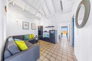 Stream your favorite services on the Smart TV in the cozy living room of this traditional Cunucu house.
