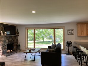 Main level living room with open floor plan to kitchen, dining & entry.