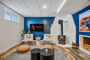 Lower level living room with a gas-lit fireplace, smart TV with cable, and cozy seating.