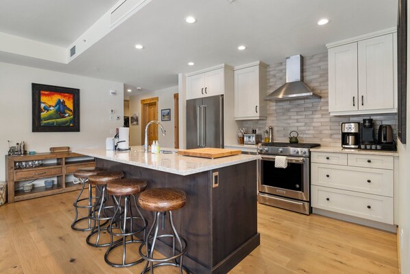 Fully equipped kitchen with stainless steel appliances and a central island for casual dining or meal prep.