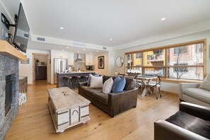 Spacious open-concept living area with cozy gas fireplace and stylish alpine decor, perfect for relaxing after a day of adventure.