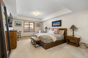 Serene master bedroom featuring a king bed, warm lighting, and direct access to a spa-style ensuite.