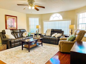 This Spacious Living room features plush reclining sofas, perfect for relaxation