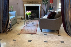 Large private sitting room with open log fire. Comfy seating perfect for remote working or just relaxing. Travertine tiled flooring with rugs.
