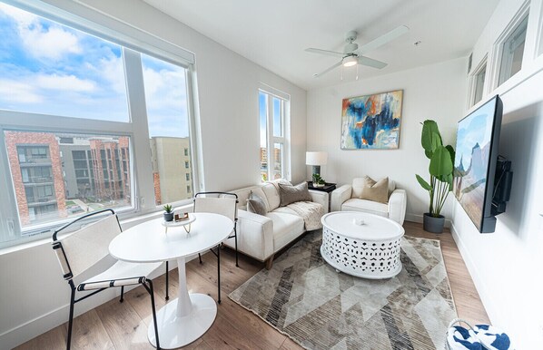 Beautifully designed living room. 65" TV, comfy sofa and amazing views of mountains and city skyline.