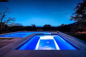 The pool glows under the twilight sky, offering pure serenity.
