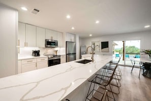 Spacious kitchen with a large island and seating, ideal for enjoying morning coffee or group meal prep.