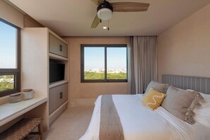 Habitación con cama king, TV, AC y ventilador en techo. Cuenta con vista al mar y un escritorio para trabajar comodamente