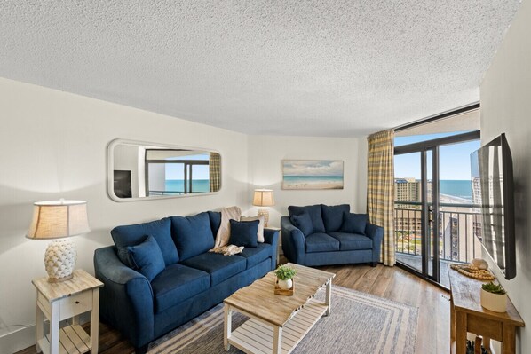 This living room gives you the ideal ocean view with access to a large balcony.  Relax on these plush couches with seating for 6 and a Smart TV perfect for streaming your favorite shows.  Floor to ceiling windows give you the energy of natural ight.
