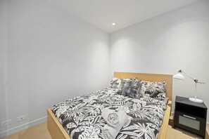 The 2nd bedroom with a queen sized bed & plush pillows.