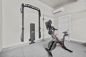 Get your workout on in the Gym! Completed with a Peloton and weight rack
