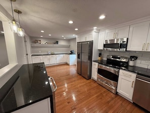 Large kitchen with different types of coffee makers, beverage fridge, electric range and many additional appliances in the cabinets. Essentials for cooking provided. Cast-iron skillet.