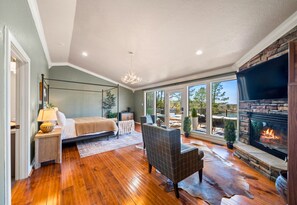 Wake up to stunning lake views from this luxurious bedroom, featuring a cozy fireplace and comfortable seating for quiet mornings.