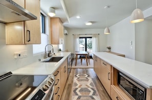Kitchen with view to dining area and door to deck.