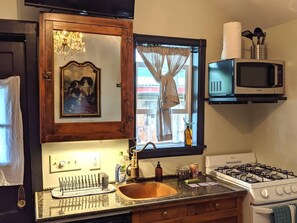 Kitchen area and TV, facing the bed