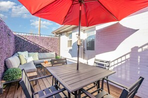 1st Unit: Private patio with a lounge area plus a dining table with an umbrella.