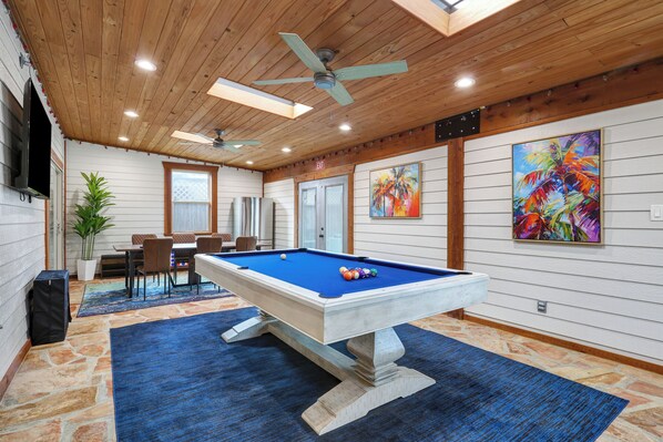 Includes pool and air hockey tables, a 65" Roku TV, and a dedicated refrigerator!
