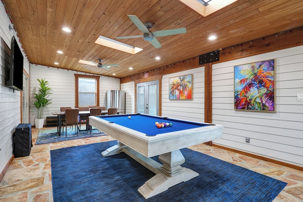 Includes pool and air hockey tables, a 65" Roku TV, and a dedicated refrigerator!