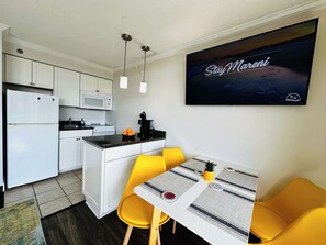 Start your mornings right in this cozy kitchen and dining nook, complete with bright seating, a coffee maker, and a smart TV to enjoy while you sip and plan your beach day.