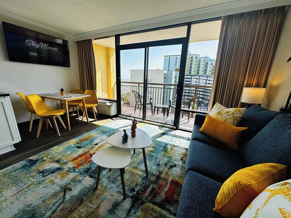 Bright and modern beachfront condo with balcony views, bold decor, and cozy touches—perfect for relaxing after a day in the sun or enjoying a quiet meal with a view.