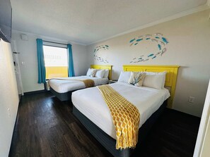 Coastal charm meets comfort in this bright double-bed room featuring ocean-inspired decor, vibrant accents, and plenty of natural light for a refreshing retreat.